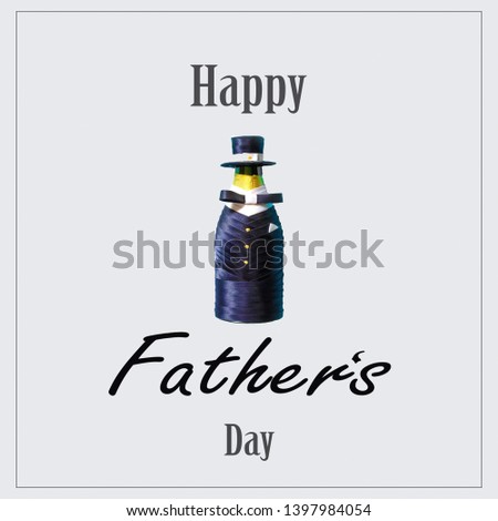 Happy father's day. The inscription on the greeting card with a bottle of wine, decorated in a men's suit and hat. Flat lay top view with copy space.