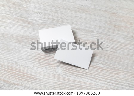 Blank white business cards on light wooden background. Mockup for branding identity. Template for graphic designers portfolios.