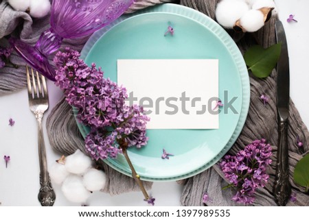 Beautiful spring wedding event table set up mock up with boho style lilac flower decoration and invitation card. Top view flat lay mockup.