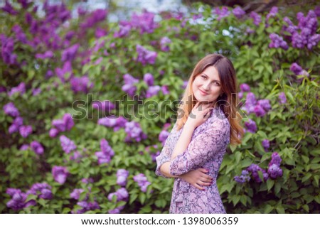 Young beautiful woman in a pink dress on a lilac background. Spring outdoors park. 
