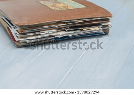 old photo album with photos on a light wooden table.Copy space.