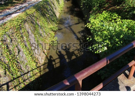 Shadow of three women and bridge on canal