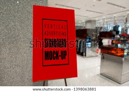 Mock up perspective blank vertical advertising signboard in frame on stand with clipping path at front of clothing shop in shopping mall ,empty space for insert discount or promotion 