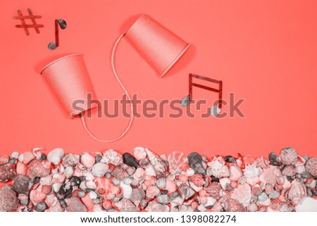 Coffee cups connected into communication device on pink background