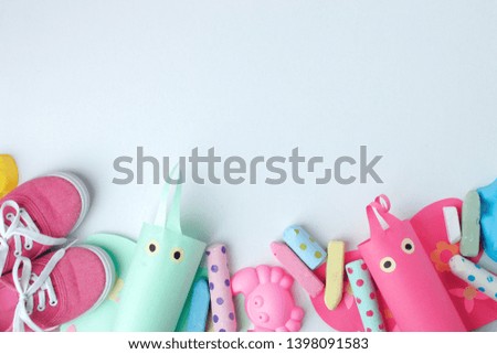 Toys and pink sneakers on pastel background from above with copy space. Childhood - holiday or summer fun concept. 