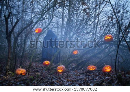 ghost with halloween pumpkins in night forest