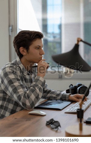 Young man working on computer in office interior