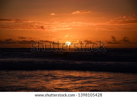 sunset at la reunion island golden hour with the indian ocean at the beach at the surf spot with amzing clouds 