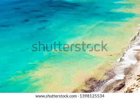 View from above on sea surface near Paphos, Cyprus. Background of yellow and turquoise rippled water. Warm fall day. Wanderlust. Copy space