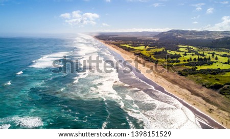 Oceanic surf on a popular beach on sunny day. Muriwai Beach, Auckland, New Zealand Royalty-Free Stock Photo #1398151529