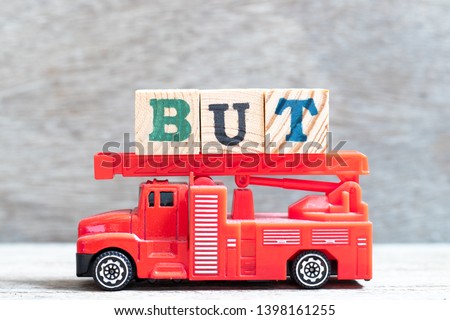 Red fire truck hold letter block in word but on wood background
