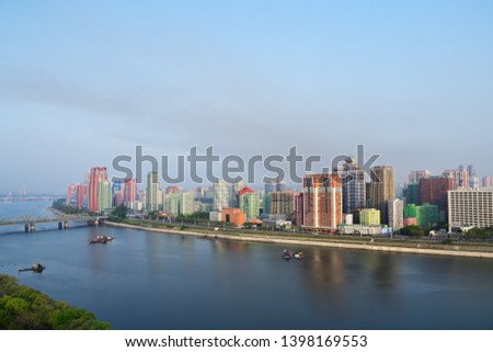 Pyongyang, DPR Korea North Korea and Taedong River in the morning fog. View on modern residential complex on the Othat Kangan street from the Yanggakdo Hotel  Royalty-Free Stock Photo #1398169553
