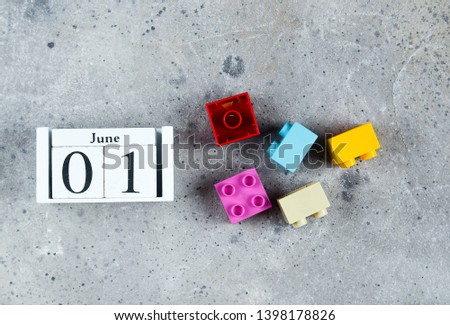 Happy Children's Day. Wooden cubes calendar date June 1st and colorful plastic cubes on gray background. Creative Top view Flat lay Template