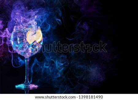 gin tonic cocktail splashing in blue and purple smoky background	 Royalty-Free Stock Photo #1398181490