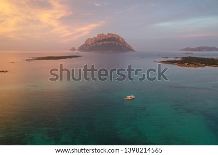 Aerial seascape of Sardinia coastline, islet Tavolara, and boat on the
turquoise Mediterranean sea during sunset