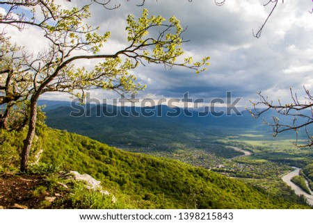 beautiful spring view from the cliff on the mountains and mountain river at sunset with clouds