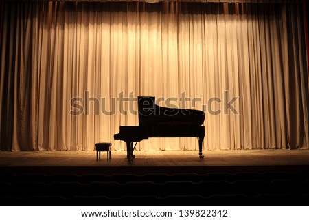 Grand piano at concert stage with brown curtain Royalty-Free Stock Photo #139822342