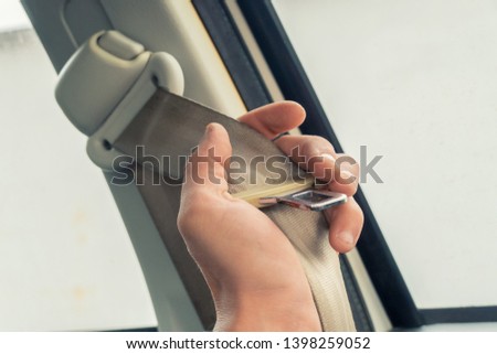 Hand Holding Safety Seat Belt in The Car, A Vehicle Safety Device Use For Secure The Car Accidents and Occupant Ejection. Royalty-Free Stock Photo #1398259052