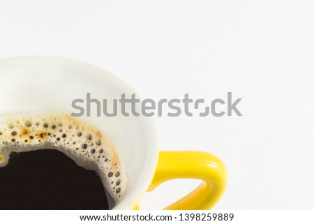 Close-up of a yellow coffee cup with espresso on a white background