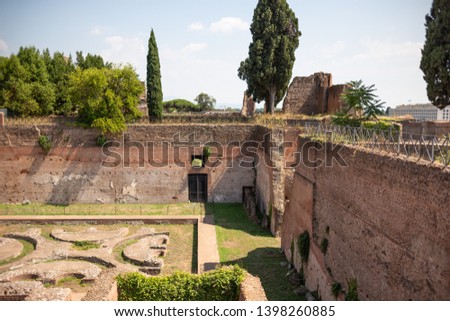 green trees and roman ruins on a sunny day with a medium shot