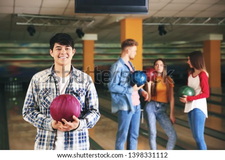 Young man with friends in bowling club