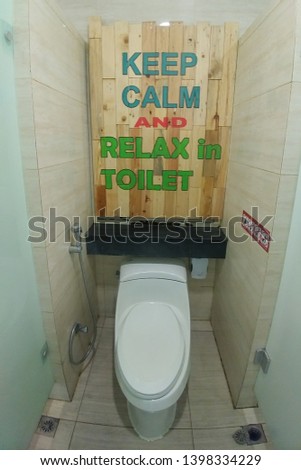 The toilet over which is written Keep Calm an relax in toilet