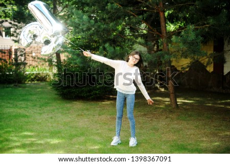 Beauty brunette teenager girl with thirteen ballons having fun outdoor