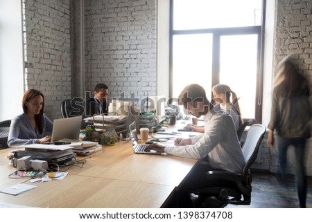 Multi-ethnic office workers sitting at shared table working together using computers. Millennial corporate members team diverse people having busy workday. Coworking collaboration and teamwork concept Royalty-Free Stock Photo #1398374708