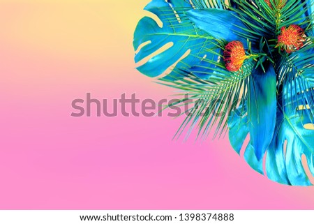 Trendy turquoise colored close up of various fresh tropical leaves and red flowers on pink background. Design template. Frame with copy space for text. Top view, flat lay