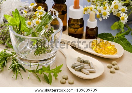 Alternative Medicine. Rosemary, mint, chamomile, thyme in a glass mortar. Essential oils and herbal supplements. Royalty-Free Stock Photo #139839739