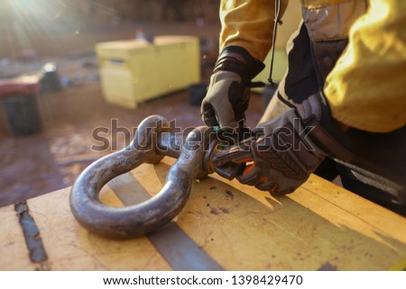 Rigger wearing a safety glove inspecting, tagging safety crane lifting 17 tone equipment with green plastic tag prior used construction mine site, Perth, Australia   
 Royalty-Free Stock Photo #1398429470