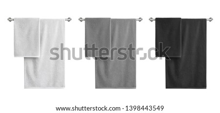 White, black and grey cotton terry towels hanging on a rail isolated  Royalty-Free Stock Photo #1398443549
