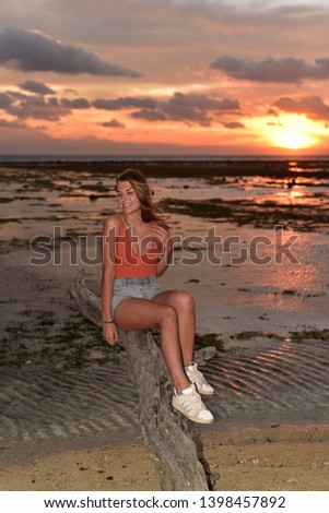 Tourist watching a relaxing sunset sitting on the beach, Gili Islands, Gili Trawangan, Indonesia