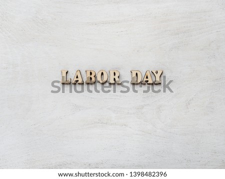 Wooden letters with a congratulatory inscription LABOR DAY. Close-up, top view, isolated. Concept of preparing for the holiday. Congratulations for loved ones, relatives, friends, colleagues
