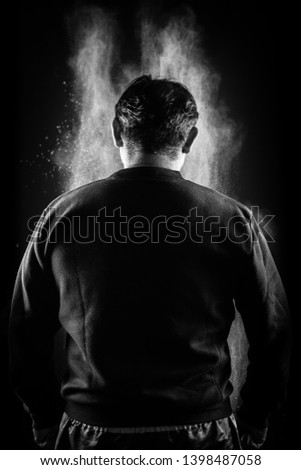 Man's back on black background with grey fog