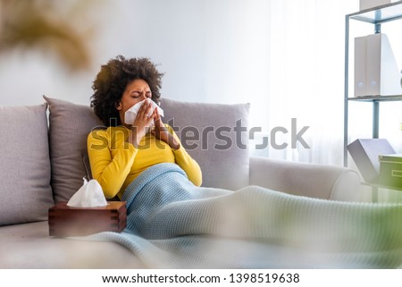 Picture showing sick woman sneezing at home. Young sick woman sneezing in tissue sweating from flu fever. Sick woman catch cold. Sneezing with handkerchief, coughing, got flu, having runny nose.  Royalty-Free Stock Photo #1398519638
