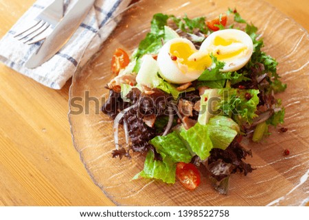 American cobb salad with greens, bacon and eggs for a rustic dinner