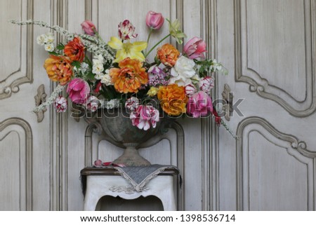 Floral composition with bouquet of fresh multicolour flowers in aged metal vase, planter, flowerpot on wooden weathered background, daylight, vintage style