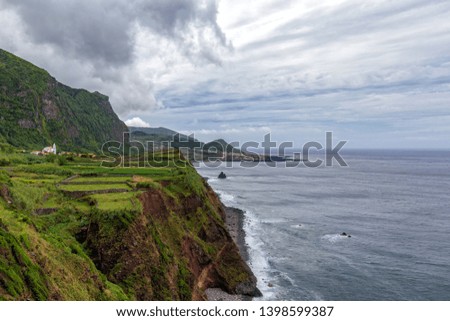 Wide angle view of the church and farmland in Ponta da Faja village on Flores island in the Azores.