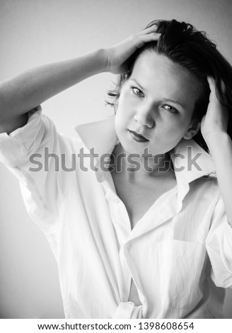 portrait of a girl in a white shirt with her hair down light from the window, black and white image