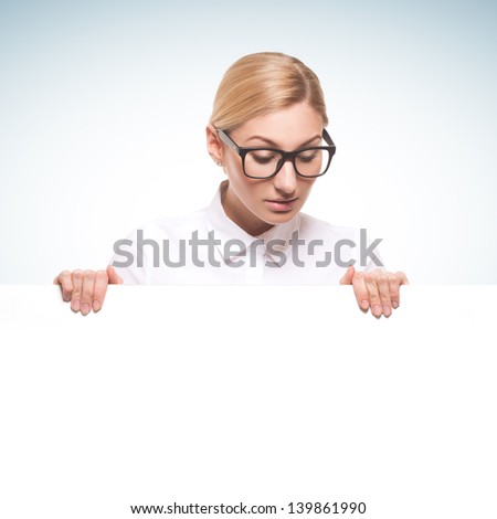 Beautiful businesswoman wearing glasses holding a white billboard isolated on white background
