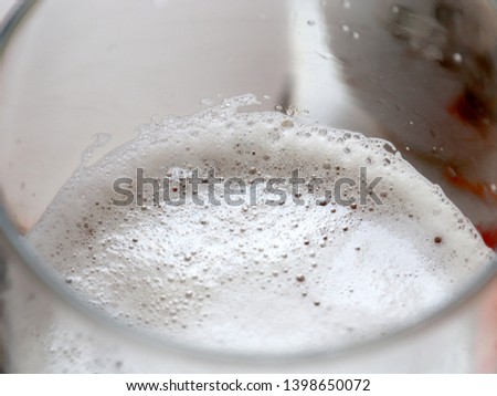air bubbles in the foam on the surface of light beer