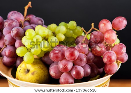 ripe grapes and pears in a bowl