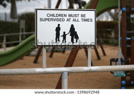 Warning sign 'Children must be supervised at all times' on a playground fence