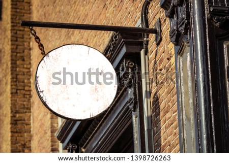 Blank round store signboard mockup street sign with empty circular shop template mounted on brick wall for signage