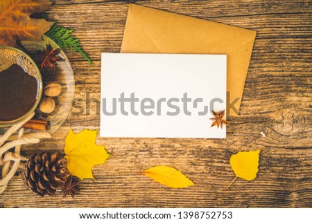 white card fall invitation, leaves and coffee on wooden autumn background, retro toned