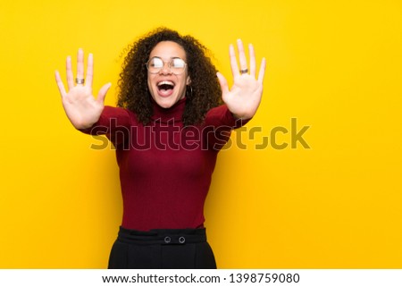 Dominican woman with turtleneck sweater counting ten with fingers