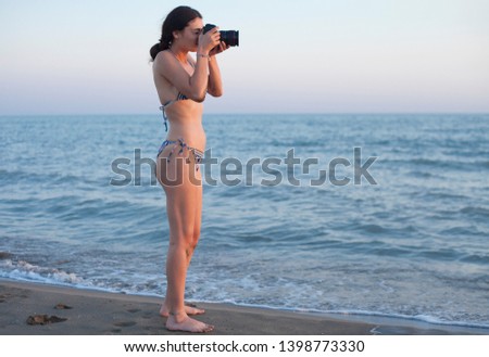 beautiful woman photographer in bikini at the beach side 