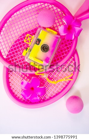 Beach tennis rackets vibrant fuchsia color with photo camera travel vacation concept top view