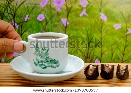 A cup of coffee using vintage cup with chocolate almond london  and sunshine in the morning.